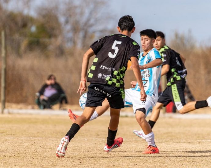 Dynamic scene of a youth soccer match on a sunny day outdoors.