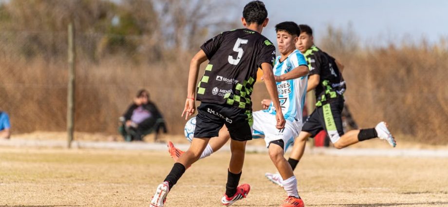 Dynamic scene of a youth soccer match on a sunny day outdoors.